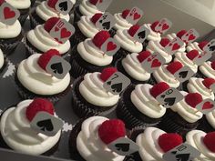 cupcakes with white frosting and red hearts are arranged in rows on top of each other