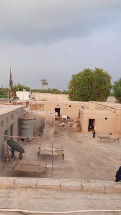 an outdoor area with several people and animals in it, including two men standing on the roof