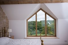 a bedroom with a large window overlooking the forest