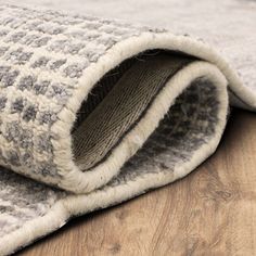 a close up view of a rug on the ground with wood flooring in the background