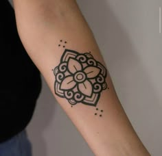 a woman's arm with a tattoo on it that has a flower in the middle