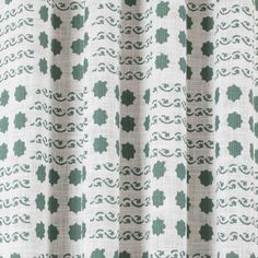 a close up view of a curtain with green and white designs on it's fabric