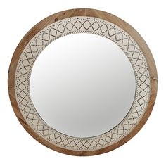 a round wooden mirror with an intricate design on the front and back sides, mounted on a white wall