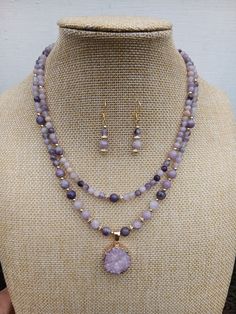 Purple mauve shades necklace and earrings set. Its  colours will give special warm summer feeling. Item Details Genuine 6-4 mm lepidolite round beads combined with 18k gold plated jewellery findings, 18k gold filled 3-4mm round beads. Drizzy quartz pendant as a center piece. Necklace 18-16" length.  Pendant  W 0.75" H 0.75" Earrings 1.25" in length, 18k gold plated over sterling silver hooks.  Please be aware that each product is handmade and unique. Materials Genuine Lepidolite, 18k gold filled Purple Double Strand Jewelry For Gifts, Elegant Double Strand Purple Jewelry, Double Strand Amethyst Gemstone Beads Jewelry, Purple Double Strand Natural Stones Jewelry, Purple Double Strand Jewelry With Natural Stones, Lavender Round Jewelry With Faceted Beads, Double Strand Purple Jewelry With Natural Stones, Lavender Spiritual Jewelry With Faceted Beads, Spiritual Lavender Jewelry With Faceted Beads