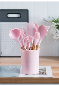 a pink cup filled with lots of utensils