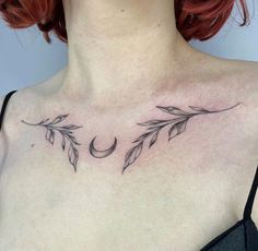 a woman's chest with an arrow, crescent and leaves tattoo on her chest