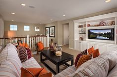 a living room filled with furniture and a flat screen tv mounted to the wall above it