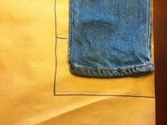 a pair of blue jeans sitting on top of a yellow sheet