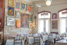 an empty restaurant with many paintings on the wall