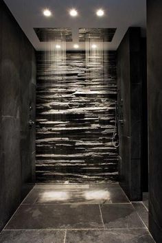 a very nice looking bathroom with some lights on the ceiling and water running down the wall