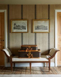 an old trunk is sitting on a bench in front of two framed pictures and paintings