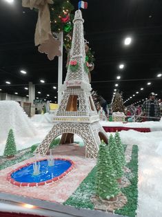 a model of the eiffel tower on display in a building with christmas decorations