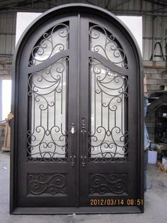 an ornate iron door with glass panels on the sides and side panels at the top