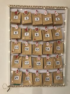 a calendar made out of brown paper with christmas decorations on it and hanging from the wall