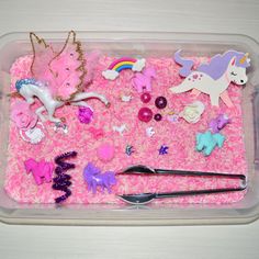 a plastic container filled with lots of toy animals and toys on top of pink carpet