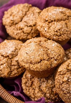 a basket filled with muffins on top of a purple cloth