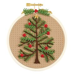 a cross stitch christmas tree ornament hanging on a wall