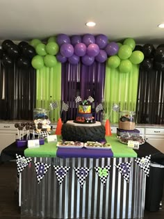 a birthday party with purple, green and black balloons