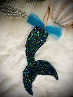 a blue and green mermaid tail ornament hanging on a white furnishing