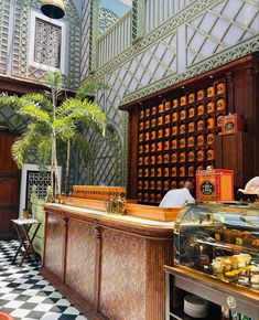 the interior of a restaurant with a checkerboard floor and wooden counter top, along with palm trees