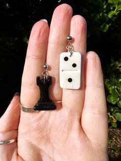 a person holding two dices in their hand, one is white and the other is black