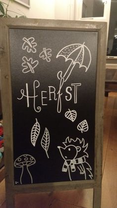 a chalk board with writing on it in front of a potted plant and other items