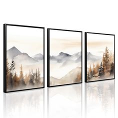 three framed paintings with mountains and trees on the wall in front of white backdrops