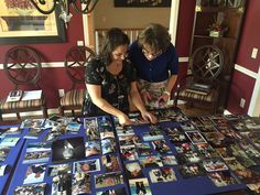 two women looking at pictures on a table