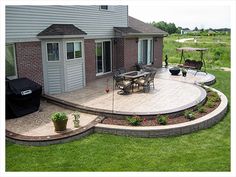 an outdoor patio with seating area and fire pit in the back yard, surrounded by green grass