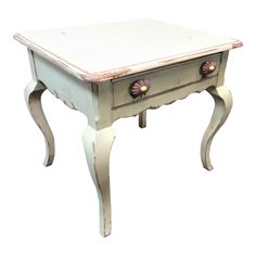 an old white table with drawers and knobs