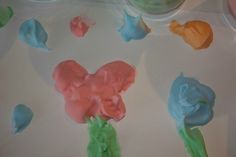 there are many different colors of icing on the trays that have been made to look like flowers