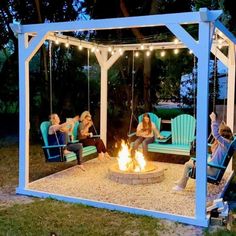 three women sitting around a fire pit in the backyard