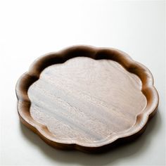 a wooden plate sitting on top of a white table