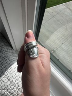 someone is holding their ring in front of the window