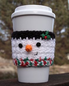 a coffee cup cozying with a snowman face on it