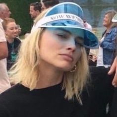 a woman with blonde hair wearing a blue hat