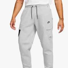 Nike Tech - Mens Sportswear Tech Fleece Utility Pant, Size L Hand Pockets Provide Quick Small-Item Storage Machine Wash A Dual-Entry Design, The Cargo Pocket On The Right Leg Is Made With A Combination Of Tech Fleece And Water-Repellent Woven Fabric; A Side Zipper Provides Secure Small-Item Storage An Elasticated Waistband And Drawcord Provide A Comfortable, Personalized Fit Inseam: 31 Inches Colorway: Dark Grey Heather/Black/Black, Large Leg Style: Tapered Pocket Style: Zipper Pocket, Utility P Sportswear Tracksuit With Pockets For Jogging, Tracksuit With Pockets For Jogging, Nike Gray Joggers For Gym, Nike Sports Sweats With Pockets, Nike Sweats With Pockets For Sports, Gray Tracksuit With Pockets For Sports, Nike Activewear With Pockets For Sports Season, Sportswear Joggers With Pockets For Sports Season, Sportswear Sweats With Pockets For Jogging