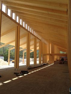 the inside of a building under construction with wooden beams and windows on each side of it