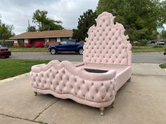 a pink bed sitting on top of a sidewalk