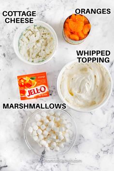 the ingredients to make orange jello are shown on a marble counter top, including marshmallows, orange cheese and whipped cream