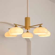 four lights hanging from a ceiling fixture in a room with white walls and flooring