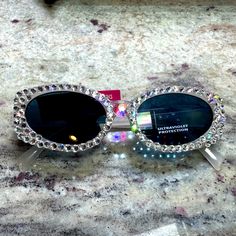 Brand New Pair Of Rhinestone Sunglasses Hand Jeweled By Me. Rhinestones Are Clear Swarovski With A Huge Swarovski A Crystal On The Bridge. You’ll Get A Few Extra Stones In Case Of Any Mishaps, But They Are Securely Glued With Industrial Glue And Sparkle Like Crazy In The Sun. Amazing For Summer And Festival Season Silver Rhinestone Sunglasses With Glass Lenses, Silver Rhinestone Sunglasses With Glass, Silver Sunglasses With Rhinestones, Glamorous Silver Sunglasses With Glass Lenses, Glamorous Silver Glass Sunglasses, Trendy Crystal Sunglasses With Rhinestones, Elegant Sunglasses With Rhinestones, Elegant Bling Sunglasses With Glass, Elegant Rhinestone Sunglasses With Glass