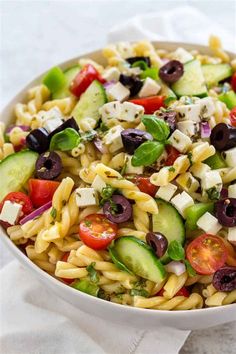 a pasta salad with cucumbers, tomatoes, olives and feta cheese