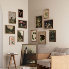 a living room filled with furniture and pictures on the wall next to a coffee table