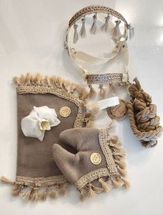 two pieces of cloth with buttons and tassels on them, one has a white flower