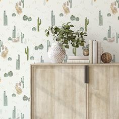 a cactus wallpaper with green leaves and cacti on the sideboard next to a bookcase