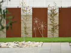 a garden with rocks and grass in front of a fence