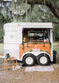 a food truck parked under a large tree