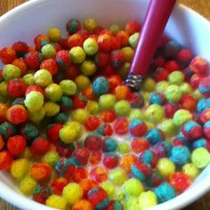 a white bowl filled with lots of colorful candy