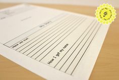 three sheets of lined paper sitting on top of a wooden table